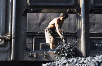 Рабочий China Coal Energy зачищает вагон с углем China Coal Energy инвестирует $ 2,8 млрд. в строительство новой шахты