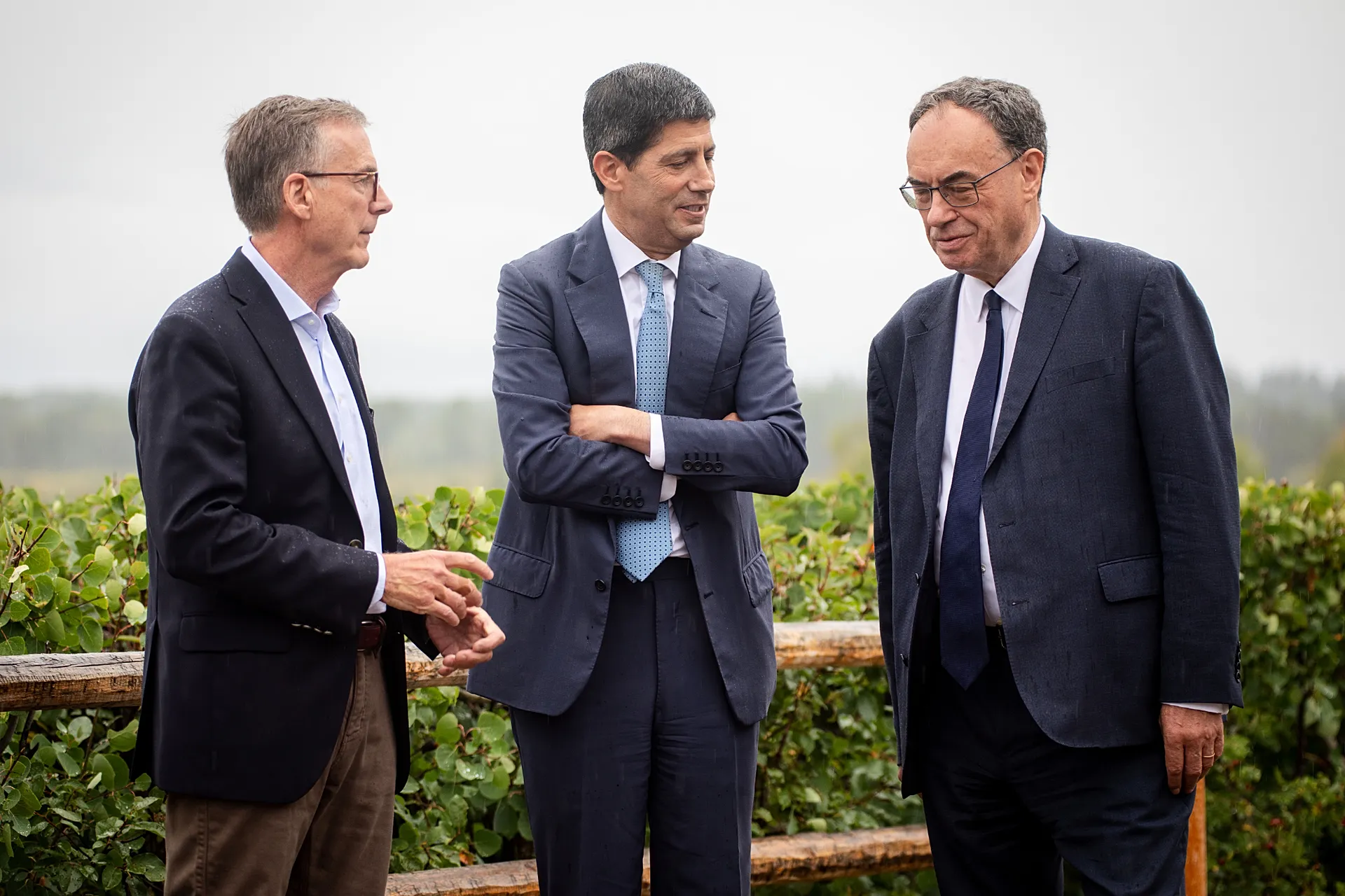 FILE. Fed Chair Kevin Warsh talks to Bank of England Governor Andrew Bailey and Bank of Canada Governor Tiff Macklem at the Jackson Hole Symposium, 28 Aug. 2026