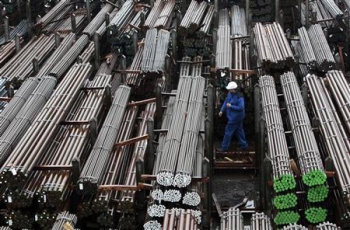 Рабочий идёт вдоль штабелей металлопроката на заводе Lech-Stahlwerke GmbH Европу в первом квартале 2014 года ожидает рост цен на сталь